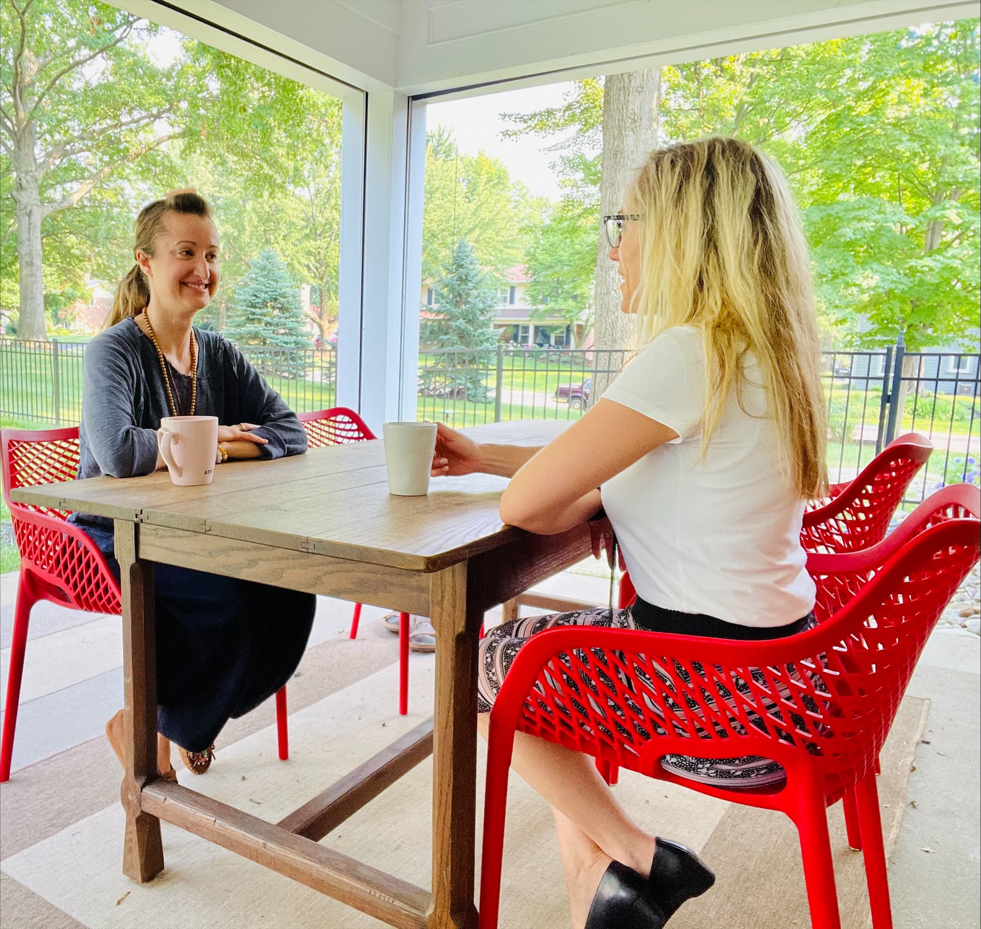 Maggie Fekete meeting with a client over coffee on a screened porch