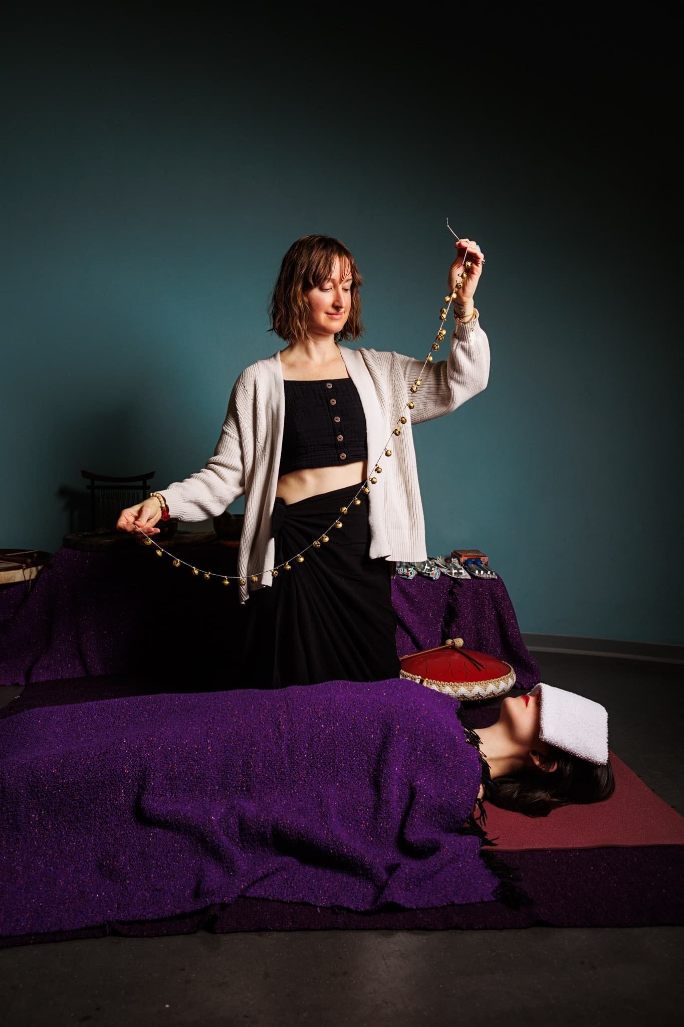 Maggie Fekete leading a sound healing session with a string of brass bells