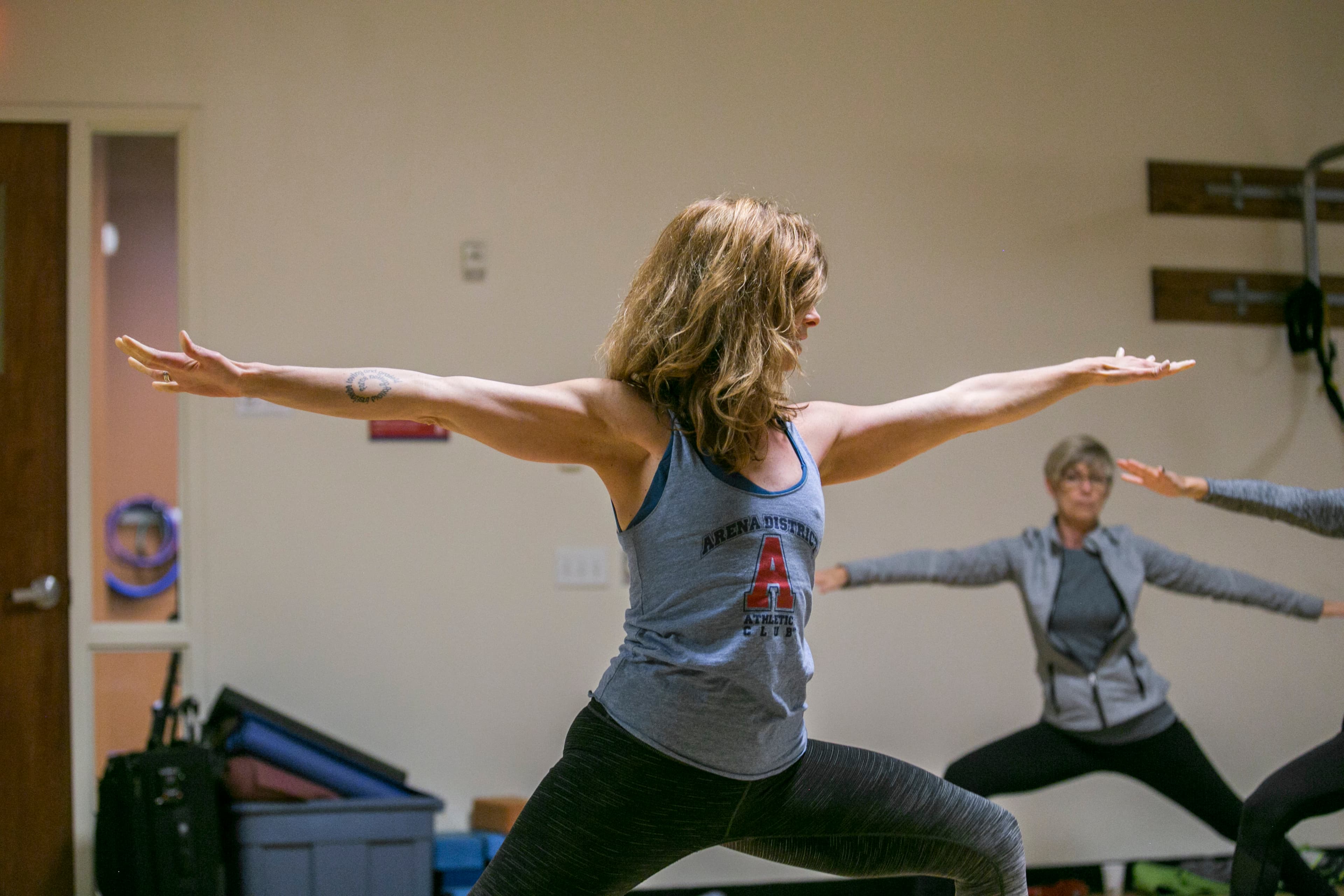 Yoga class holding warrior two pose in the ADAC group fitness studio